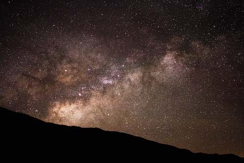 milky way silhouette of hill under starry sky stars